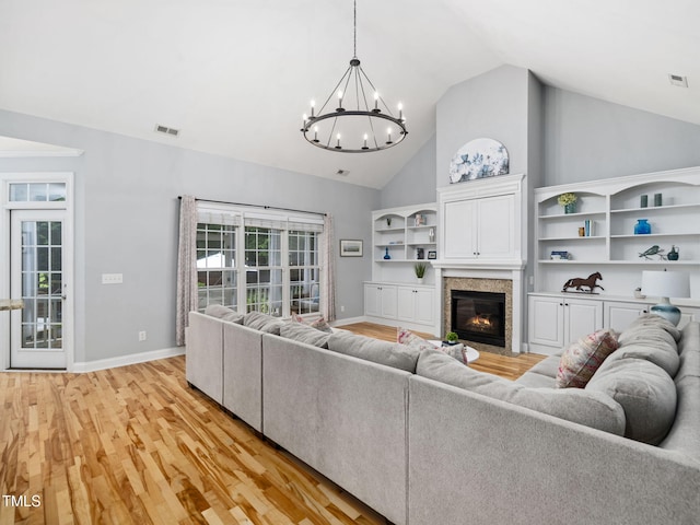 20 Little River Ct, Youngsville, NC 27596 - living room featuring a chandelier, light wood-style floors, high vaulted ceiling, and a fireplace with flush hearth