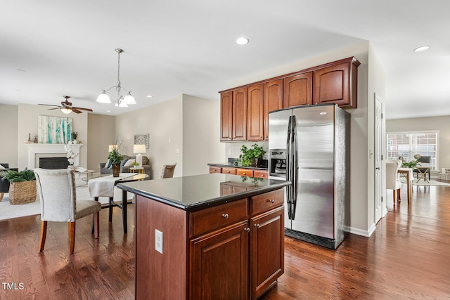 1201 Woodlands Creek Way, Apex, NC 27502 - kitchen with stainless steel fridge, dark countertops, dark wood finished floors, a center island, and recessed lighting