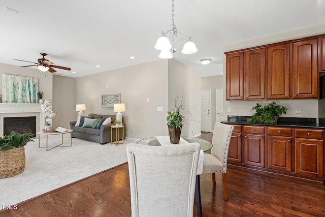 1201 Woodlands Creek Way, Apex, NC 27502 - dining space featuring a ceiling fan, dark wood finished floors, a chandelier, recessed lighting, and a glass covered fireplace