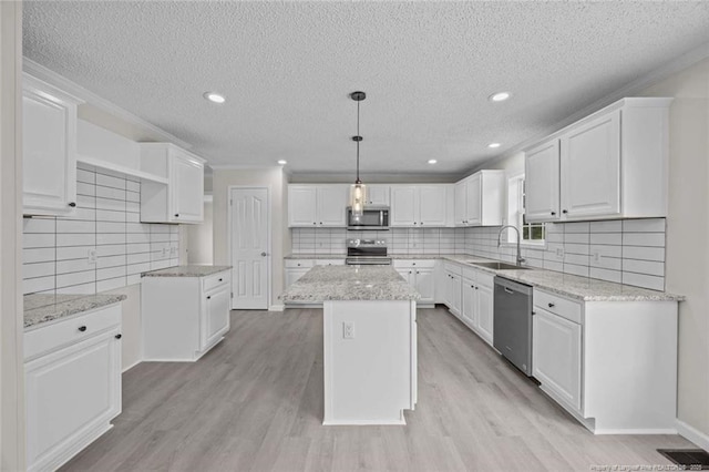 1271 Nutgrass Rd, Bunnlevel, NC 28323 - kitchen with appliances with stainless steel finishes, a textured ceiling, white cabinets, decorative backsplash, and light wood-style floors
