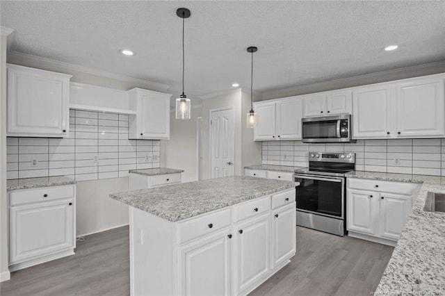 1271 Nutgrass Rd, Bunnlevel, NC 28323 - kitchen with stainless steel appliances, light wood finished floors, ornamental molding, tasteful backsplash, and a center island