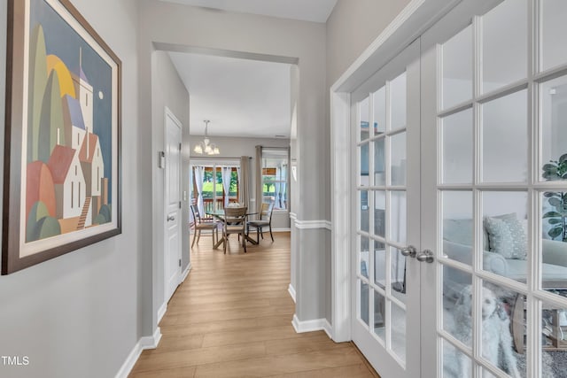 2714 Magnolia Tree Ln, Durham, NC 27703 - hall featuring french doors, a chandelier, and light wood-type flooring