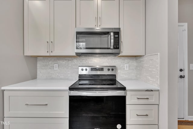 2714 Magnolia Tree Ln, Durham, NC 27703 - kitchen featuring appliances with stainless steel finishes, light countertops, and backsplash