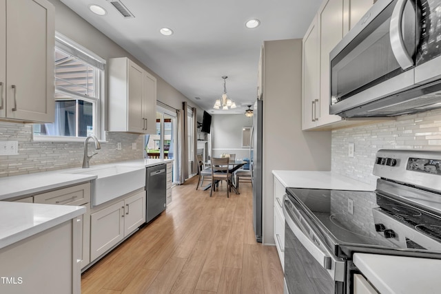 2714 Magnolia Tree Ln, Durham, NC 27703 - kitchen with stainless steel appliances, a chandelier, recessed lighting, light countertops, and tasteful backsplash