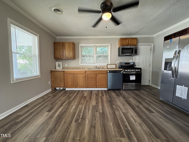 122 S 5th St, Spring Lake, NC 28390 - kitchen featuring appliances with stainless steel finishes, dark wood finished floors, brown cabinetry, ornamental molding, and a textured ceiling