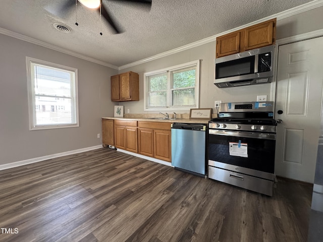 122 S 5th St, Spring Lake, NC 28390 - kitchen featuring stainless steel appliances, dark wood finished floors, ornamental molding, brown cabinets, and a textured ceiling