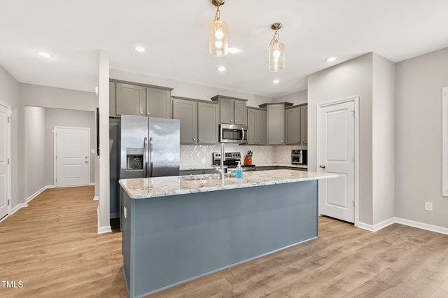 611 Laurel Lake Rd, Salemburg, NC 28385 - kitchen with appliances with stainless steel finishes, backsplash, decorative light fixtures, light stone countertops, and light wood-style flooring