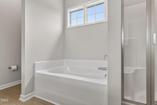 611 Laurel Lake Rd, Salemburg, NC 28385 - bathroom featuring a stall shower, a bath, and wood finished floors