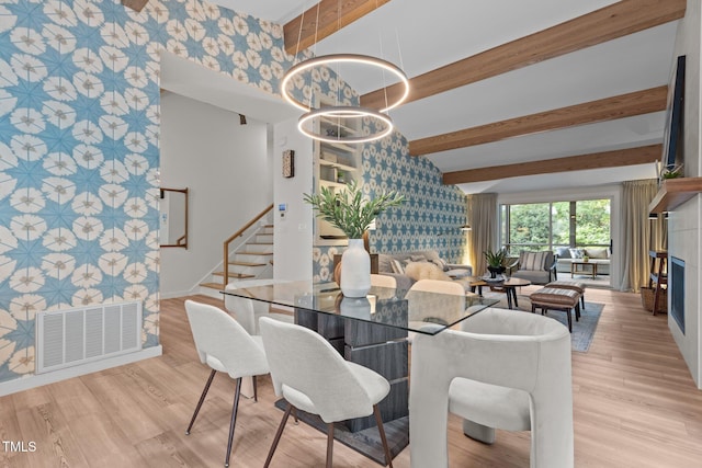 3033 Sylvania Dr, Raleigh, NC 27607 - dining space featuring wallpapered walls, beam ceiling, stairway, wood finished floors, and an accent wall
