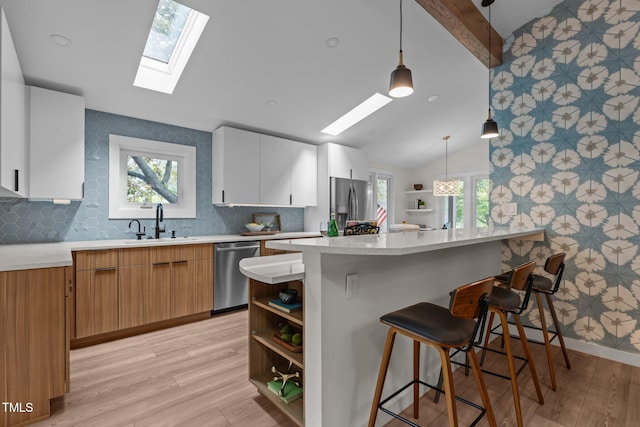 3033 Sylvania Dr, Raleigh, NC 27607 - kitchen with a skylight, open shelves, stainless steel appliances, and a breakfast bar