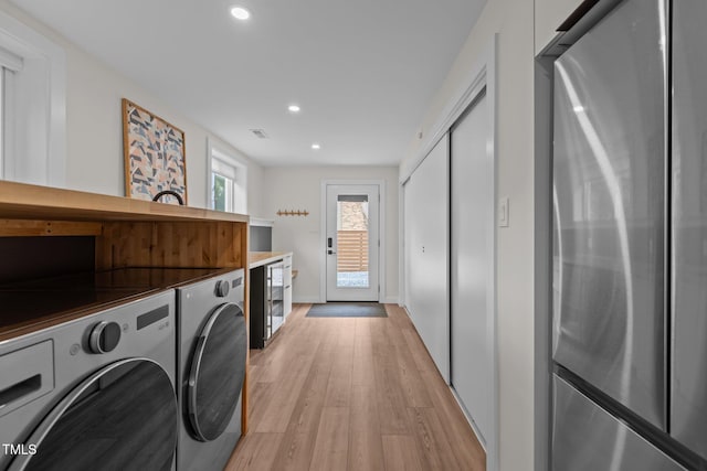 3033 Sylvania Dr, Raleigh, NC 27607 - laundry room with washing machine and clothes dryer, recessed lighting, light wood-style floors, and beverage cooler