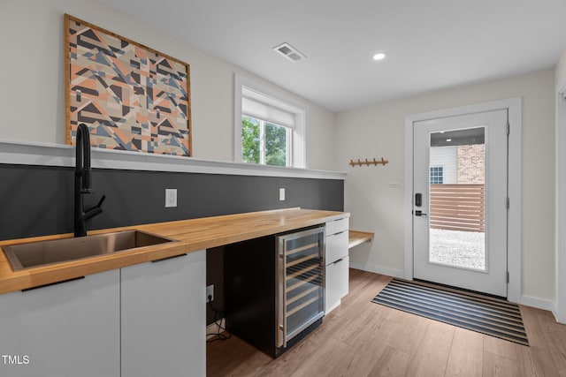 3033 Sylvania Dr, Raleigh, NC 27607 - indoor dry bar with wine cooler, light wood-style floors, and recessed lighting