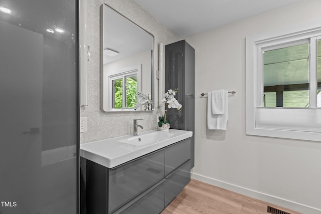 3033 Sylvania Dr, Raleigh, NC 27607 - bathroom featuring vanity, wood finished floors, and decorative backsplash