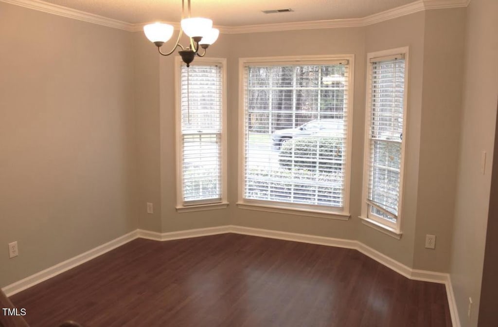 109 Gatepost Ln, Cary, NC 27513 - empty room with dark wood-style floors, crown molding, and a chandelier