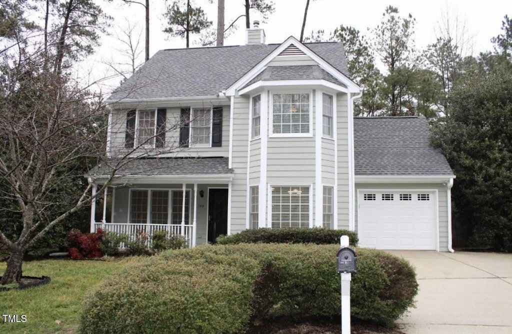 109 Gatepost Ln, Cary, NC 27513 - traditional home with a porch, concrete driveway, a garage, roof with shingles, and a chimney