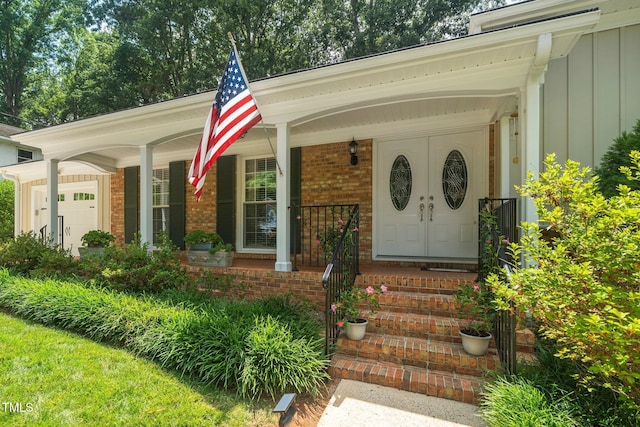 1312 Hampton Valley Rd, Cary, NC 27511 - property entrance with board and batten siding, a porch, brick siding, and a garage