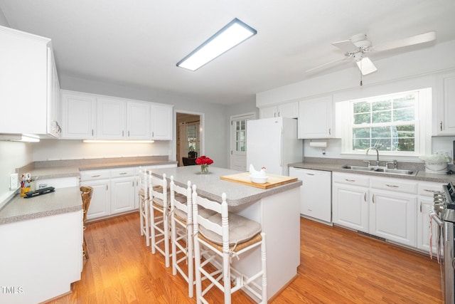 1312 Hampton Valley Rd, Cary, NC 27511 - kitchen featuring white appliances, light wood-style floors, white cabinetry, a kitchen breakfast bar, and a ceiling fan