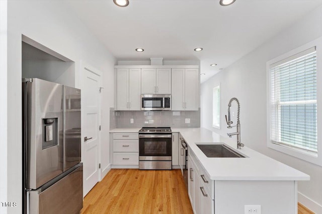 2904 Wadsworth Ave # A, Durham, NC 27707 - kitchen featuring stainless steel appliances, a peninsula, light countertops, tasteful backsplash, and recessed lighting