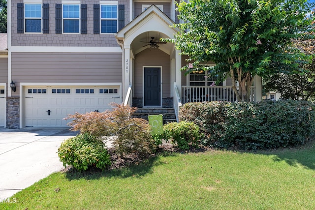 2700 Banks Lake Ct, Fuquay Varina, NC 27526 - view of front facade with stone siding, an attached garage, a front yard, and driveway