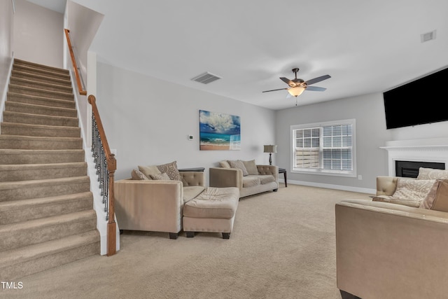 2700 Banks Lake Ct, Fuquay Varina, NC 27526 - carpeted living room featuring ceiling fan, stairway, and a fireplace