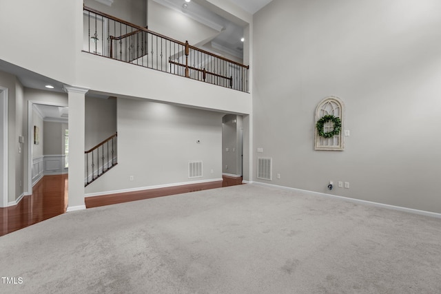 316 Hilliard Forest Dr, Cary, NC 27519 - unfurnished living room with carpet floors, a towering ceiling, stairs, and decorative columns