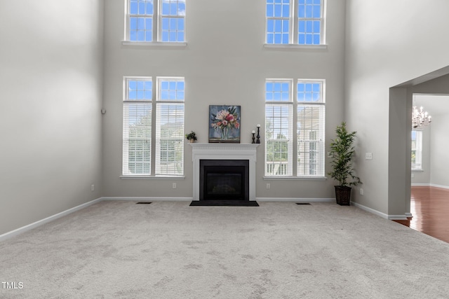 316 Hilliard Forest Dr, Cary, NC 27519 - unfurnished living room with carpet, healthy amount of natural light, a fireplace with flush hearth, and a towering ceiling