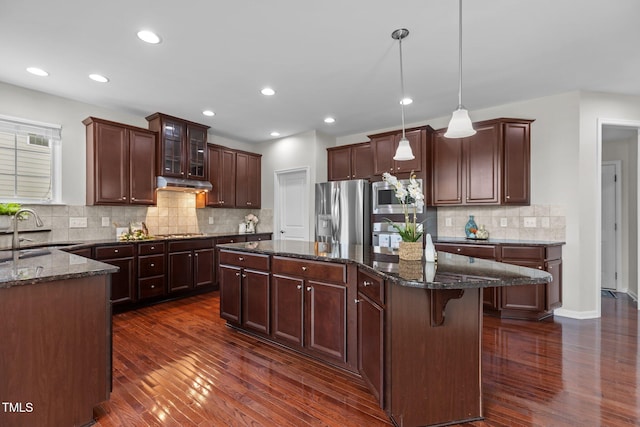 316 Hilliard Forest Dr, Cary, NC 27519 - kitchen with appliances with stainless steel finishes, a kitchen island, dark wood-style flooring, dark stone counters, and recessed lighting