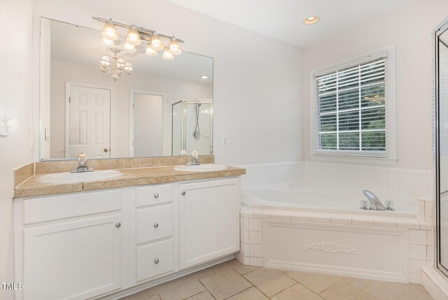 317 Yellow Poplar Ave, Wake Forest, NC 27587 - bathroom featuring a shower stall, a garden tub, double vanity, tile patterned flooring, and a chandelier