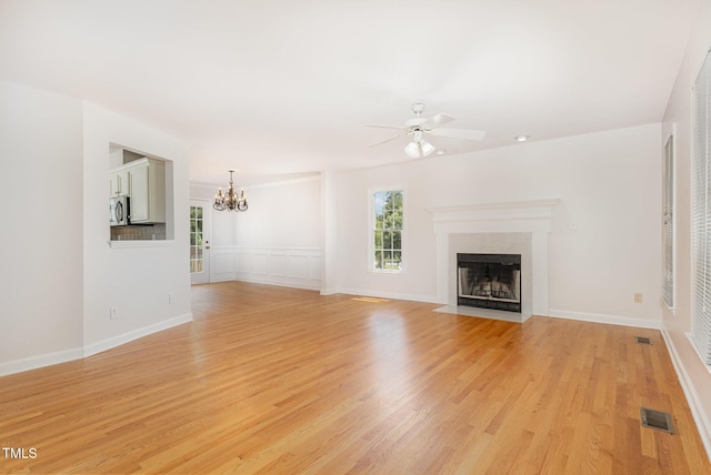317 Yellow Poplar Ave, Wake Forest, NC 27587 - unfurnished living room featuring a chandelier, ceiling fan, light wood-style flooring, and a fireplace with flush hearth