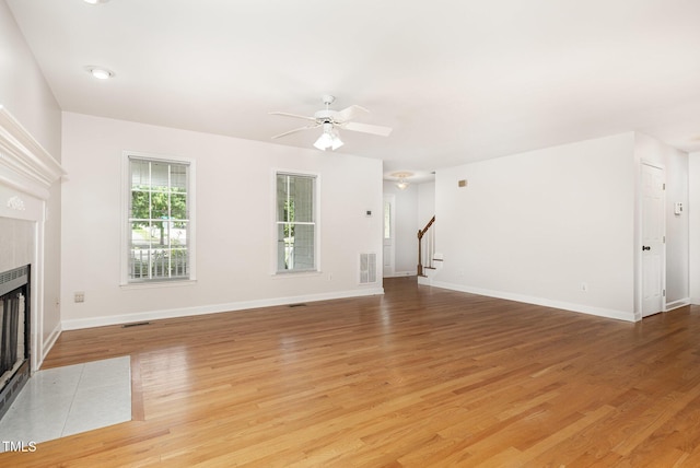 317 Yellow Poplar Ave, Wake Forest, NC 27587 - unfurnished living room with stairway, ceiling fan, light wood-type flooring, and a fireplace