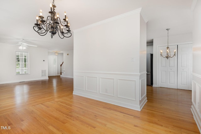 317 Yellow Poplar Ave, Wake Forest, NC 27587 - unfurnished dining area featuring a chandelier, light wood-style floors, ceiling fan, stairs, and crown molding