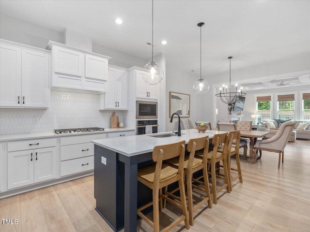 820 Whistable Ave, Wake Forest, NC 27587 - kitchen with open floor plan, stainless steel appliances, backsplash, a center island with sink, and white cabinets