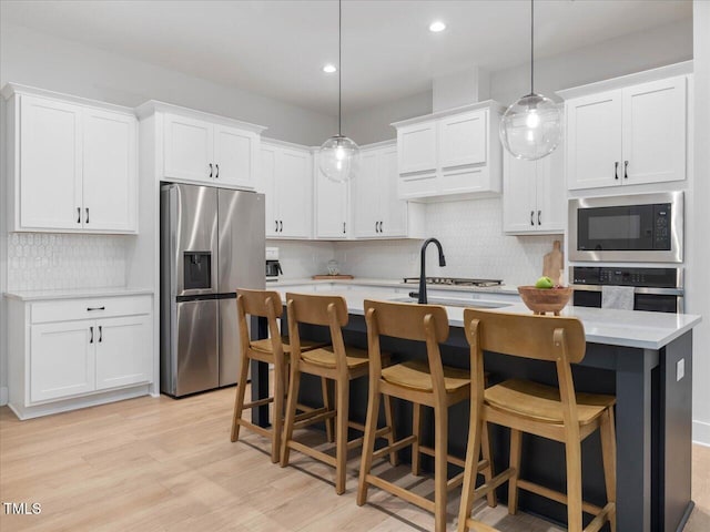 820 Whistable Ave, Wake Forest, NC 27587 - kitchen with appliances with stainless steel finishes, light countertops, backsplash, a center island with sink, and white cabinets