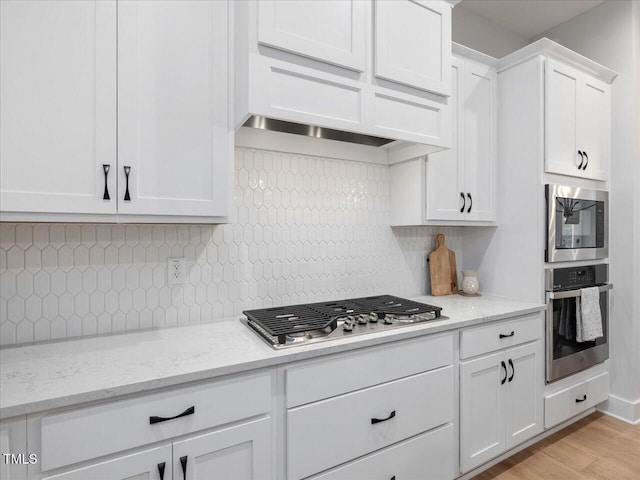 820 Whistable Ave, Wake Forest, NC 27587 - kitchen with stainless steel appliances, white cabinetry, decorative backsplash, and light wood finished floors