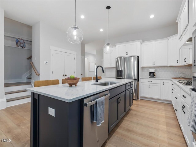 820 Whistable Ave, Wake Forest, NC 27587 - kitchen featuring stainless steel appliances, white cabinetry, an island with sink, backsplash, and light stone countertops