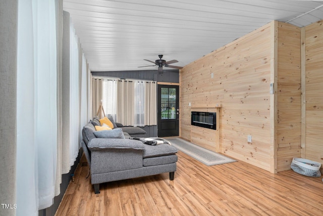 196 Red Wing Dr, Louisburg, NC 27549 - living room with wood walls, wood finished floors, a glass covered fireplace, ceiling fan, and vaulted ceiling