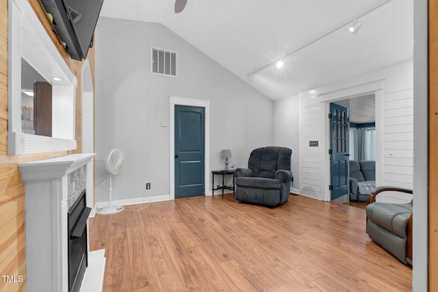 196 Red Wing Dr, Louisburg, NC 27549 - living area featuring vaulted ceiling, light wood-style floors, track lighting, a glass covered fireplace, and ceiling fan