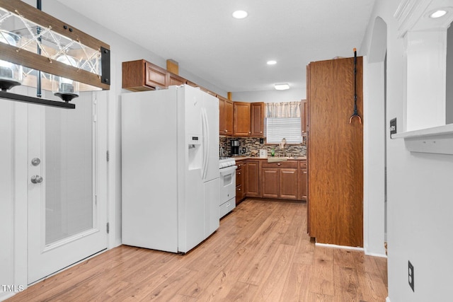 196 Red Wing Dr, Louisburg, NC 27549 - kitchen with white appliances, brown cabinets, light wood-type flooring, recessed lighting, and healthy amount of natural light