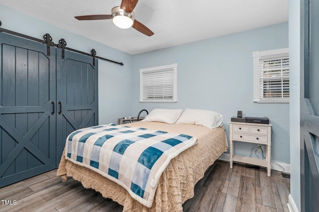 196 Red Wing Dr, Louisburg, NC 27549 - bedroom with a barn door, wood finished floors, and ceiling fan
