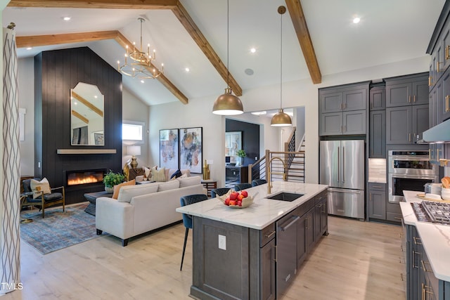 6104 Hope Farm Ln Unit 2, Wake Forest, NC 27587 - kitchen featuring stainless steel appliances, light wood finished floors, light stone countertops, a fireplace, and beamed ceiling