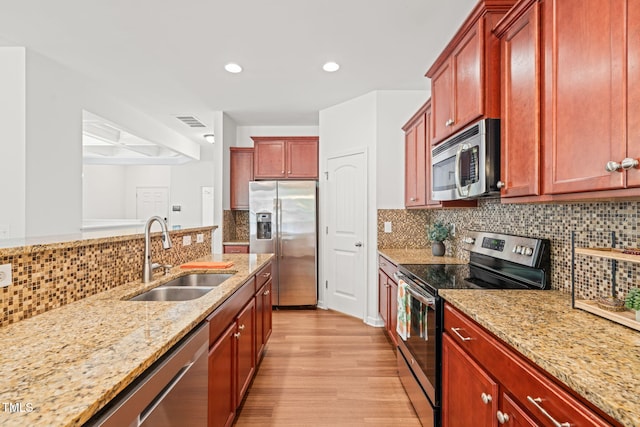 120 Holly Berry Ln, Durham, NC 27703 - kitchen featuring stainless steel appliances, light wood finished floors, light stone counters, decorative backsplash, and recessed lighting