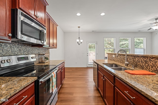 120 Holly Berry Ln, Durham, NC 27703 - kitchen with appliances with stainless steel finishes, tasteful backsplash, dark wood-type flooring, recessed lighting, and light stone counters