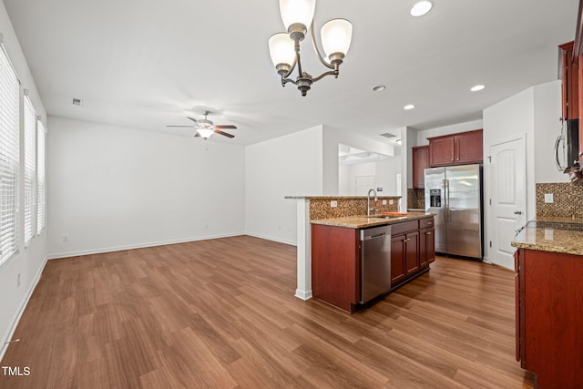 120 Holly Berry Ln, Durham, NC 27703 - kitchen featuring stainless steel appliances, tasteful backsplash, ceiling fan, wood finished floors, and recessed lighting
