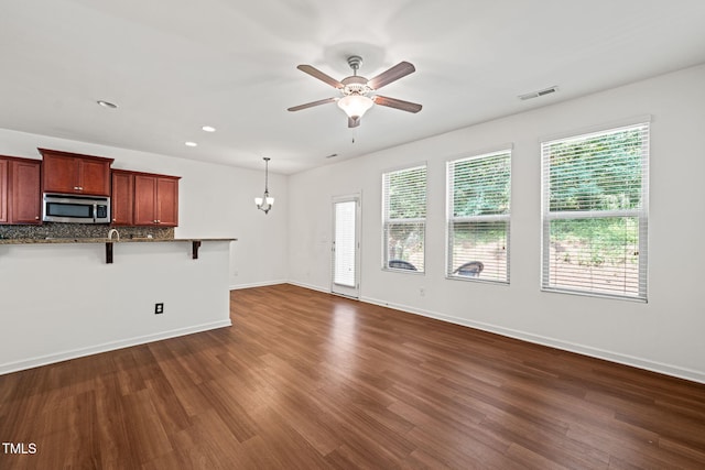 120 Holly Berry Ln, Durham, NC 27703 - unfurnished living room featuring healthy amount of natural light, ceiling fan, dark wood-style flooring, recessed lighting, and a chandelier