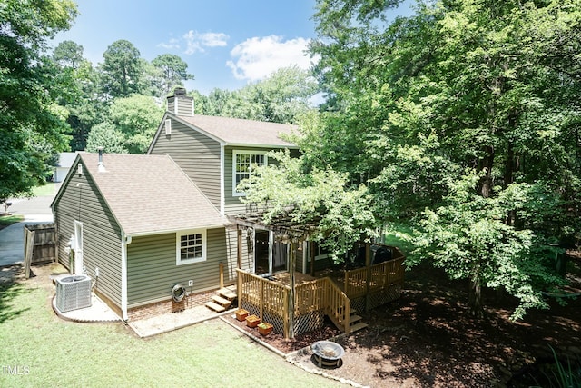 10 Biltmore Pl, Durham, NC 27712 - back of property featuring a wooden deck, a chimney, a shingled roof, and a yard