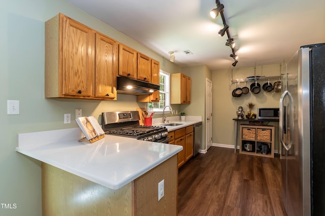 10 Biltmore Pl, Durham, NC 27712 - kitchen with stainless steel appliances, under cabinet range hood, a peninsula, dark wood-style floors, and track lighting