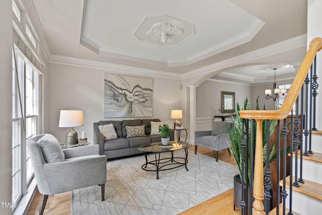 100 Beraneak Ln, Cary, NC 27519 - living room featuring a tray ceiling, arched walkways, a chandelier, light wood finished floors, and crown molding