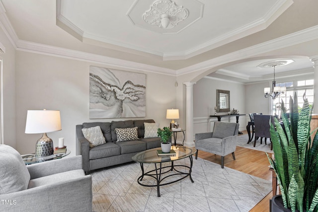 100 Beraneak Ln, Cary, NC 27519 - living room with decorative columns, a tray ceiling, a chandelier, arched walkways, and ornamental molding