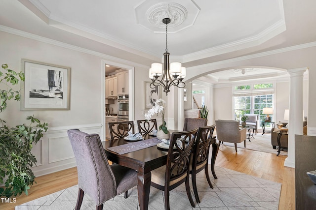 100 Beraneak Ln, Cary, NC 27519 - dining room with light wood-type flooring, arched walkways, a raised ceiling, ornamental molding, and a chandelier