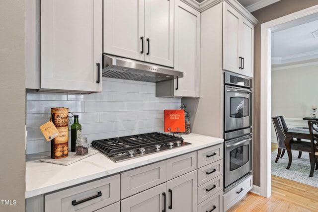 100 Beraneak Ln, Cary, NC 27519 - kitchen featuring stainless steel appliances, range hood, ornamental molding, light wood-style flooring, and light stone counters